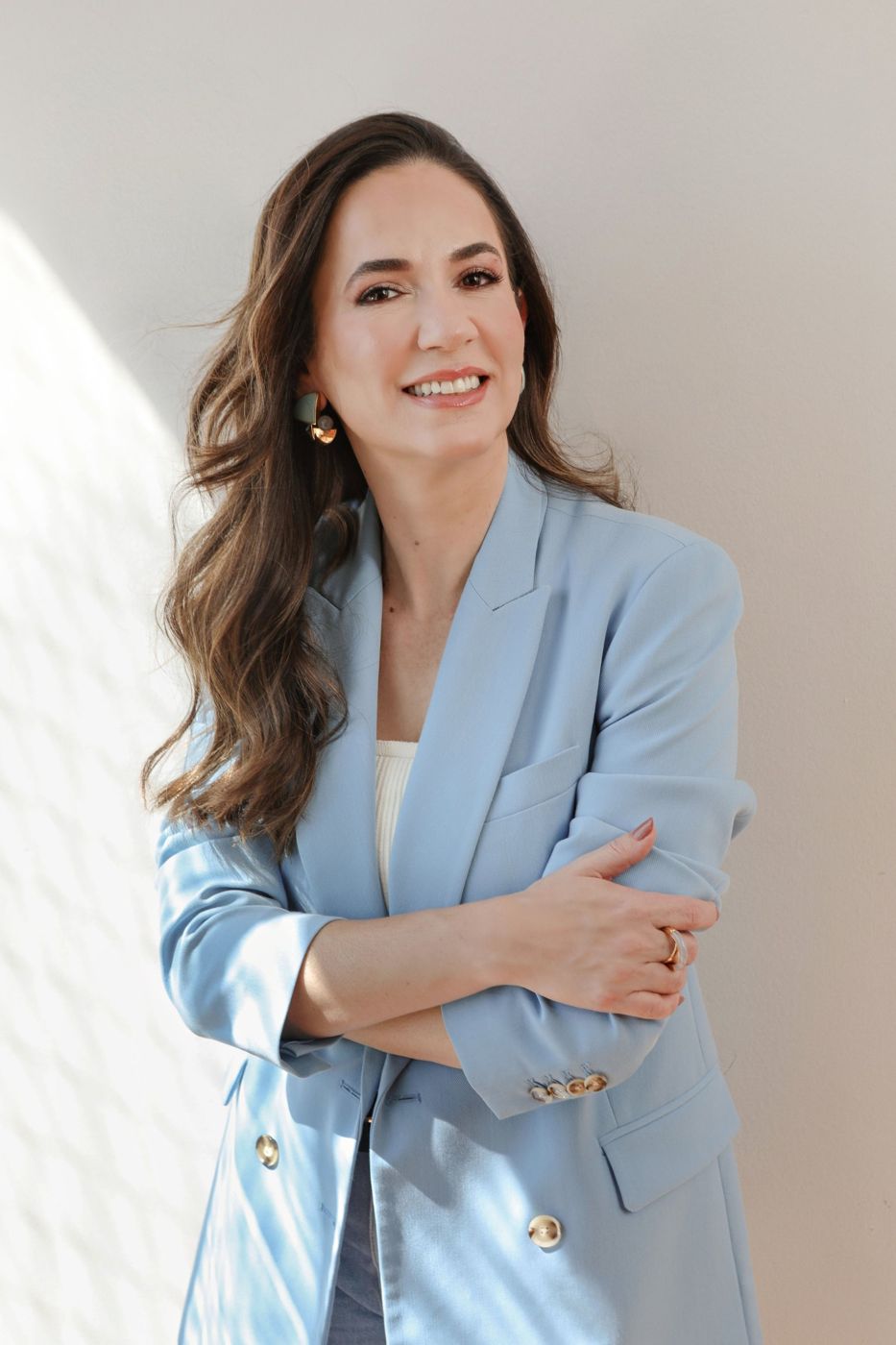 Márcia Cunha Shimizu, psicanalista, sorrindo, de blazer azul-claro, em luz natural