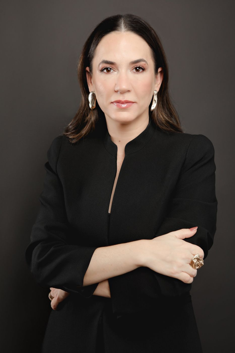 Márcia Cunha Shimizu de blazer preto, braços cruzados, olhar à câmera